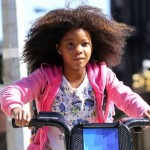 Quvenzhane Wallis rides a public bike while shooting the remake of 'Annie', on location in Harlem, NY