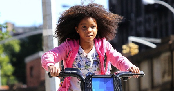 Quvenzhane Wallis rides a public bike while shooting the remake of 'Annie', on location in Harlem, NY